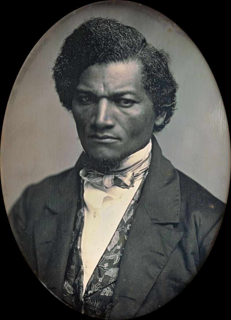 Daguerreótipo de Frederick Douglass jovem, de rosto sério, cabelo volumoso e casaco escuro, olhando para o espectador