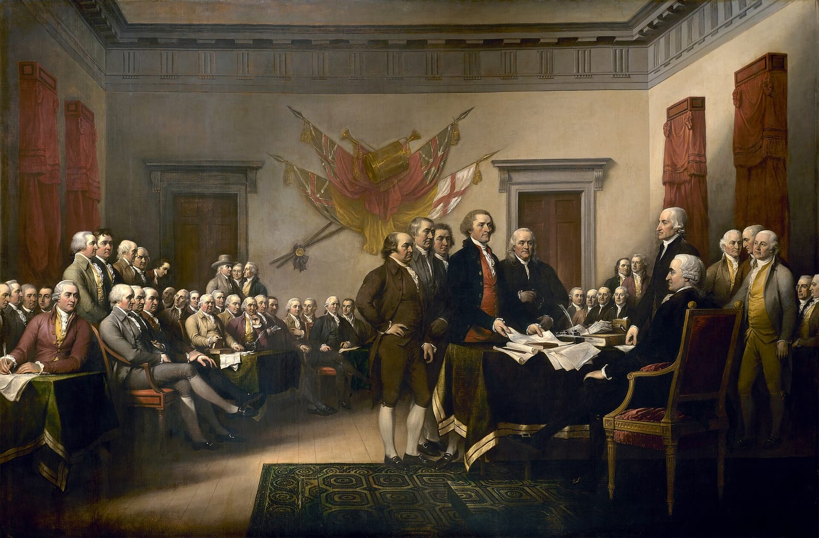 Pintura de John Trumbull: cinco homens, entre eles Jefferson e Franklin, entregam o texto da Declaração de Independência a John Hancock numa sala cheia de delegados