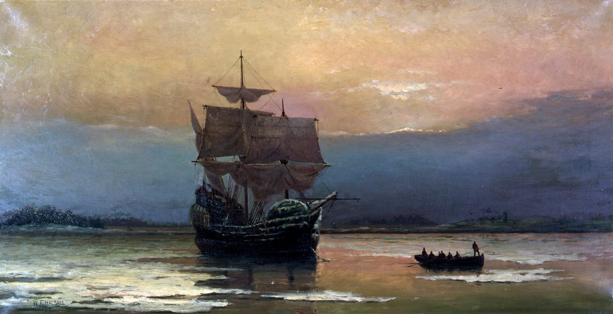 O Mayflower ancorado ao pôr do sol, com um bote de remadores em primeiro plano, num porto frio de céu amarelo e azul