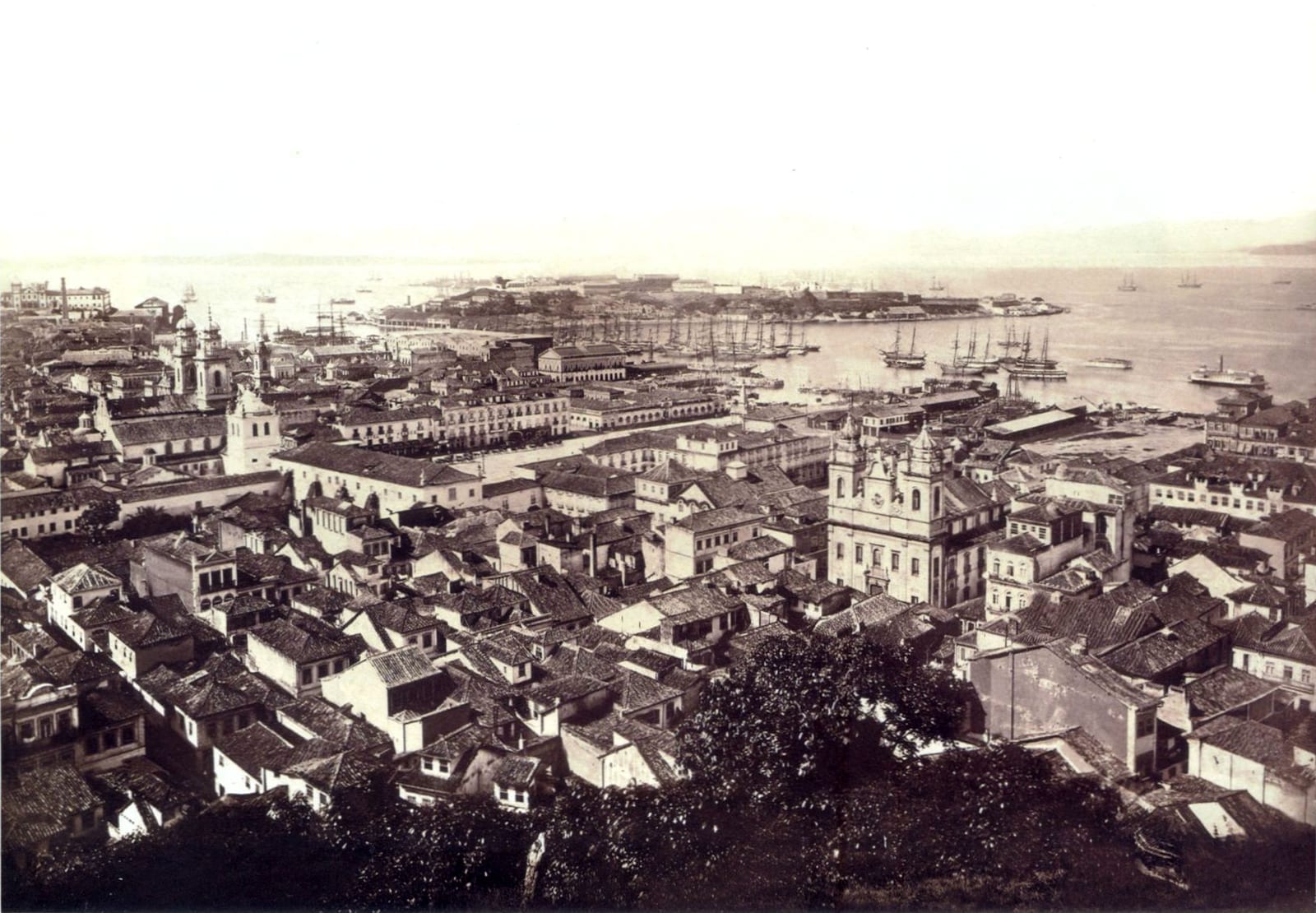 Fotografia panorâmica do Rio de Janeiro visto do Morro do Castelo, com telhados, torres de igrejas e a baía ao fundo