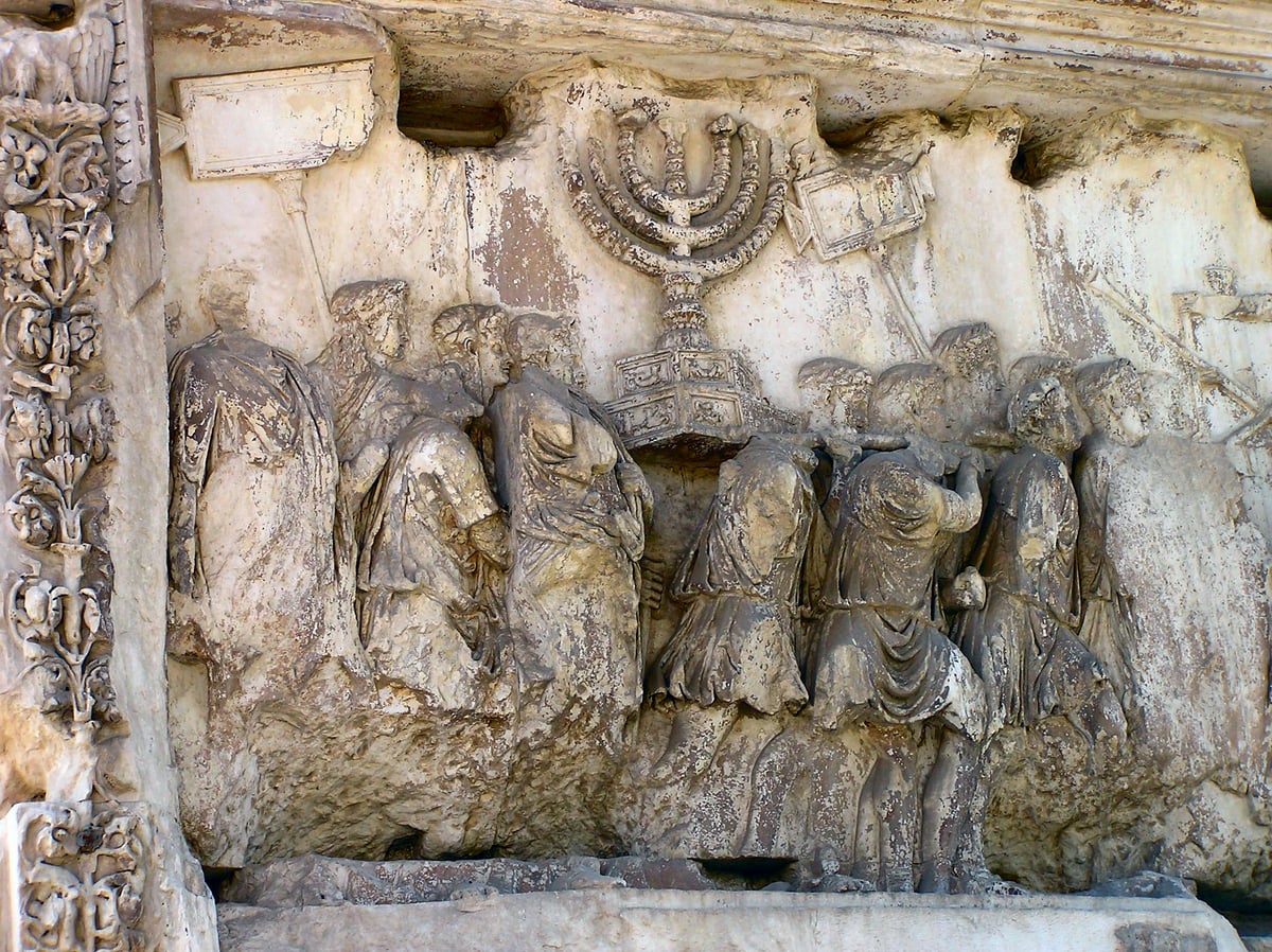 Relevo de mármore do Arco de Tito mostrando soldados romanos carregando o candelabro de sete braços e outras peças do Templo
