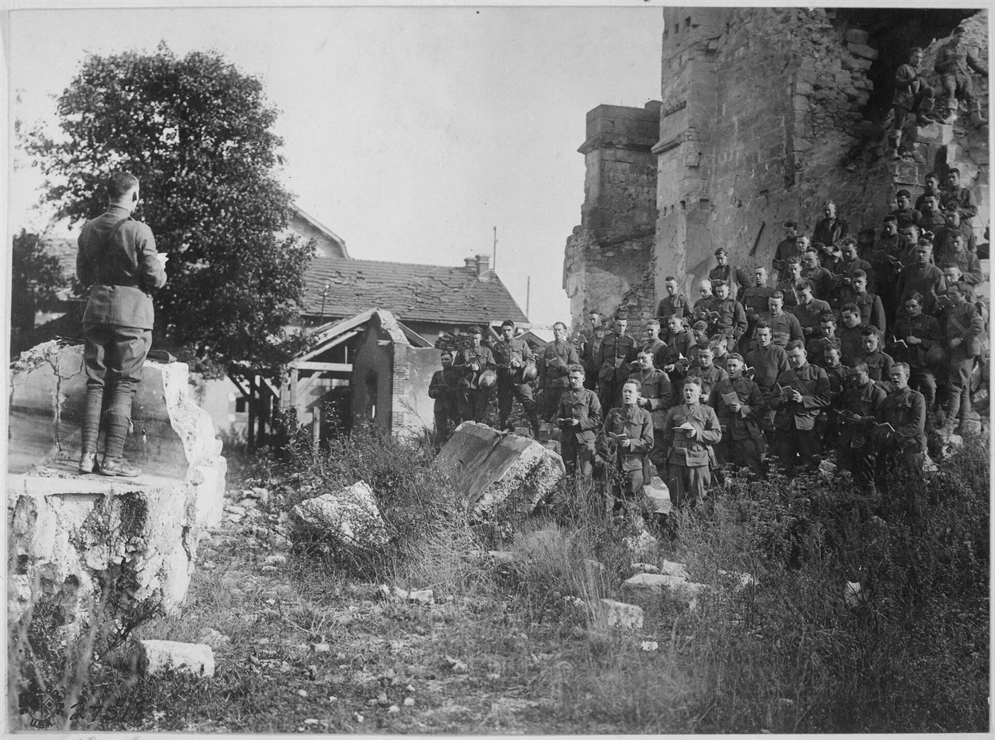 Fotografia de 1918: soldados americanos cantam em culto ao ar livre diante das ruínas de uma igreja, em Verdun